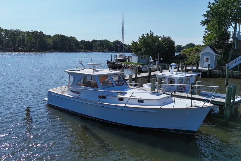 Slide: The Image of 2002 Legacy Express boat docked by a scenic waterfront with trees and buildings. - 34