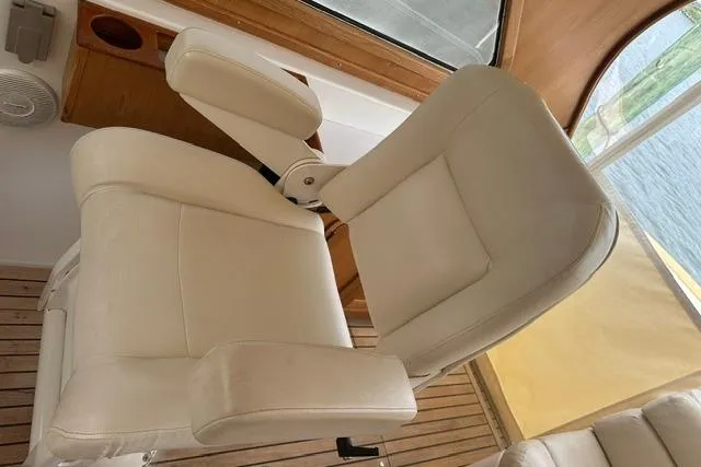 Slide: The Image of White leather boat seat inside a 2002 Legacy Express, with wooden interior accents. - 9