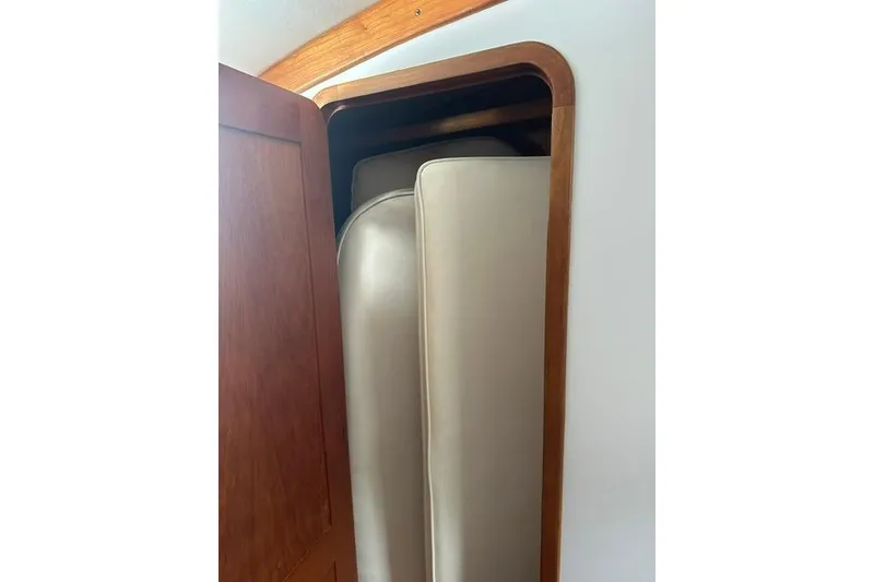 Slide: The Image of Cabinet with beige cushions inside a 2002 Legacy Express boat. - 21