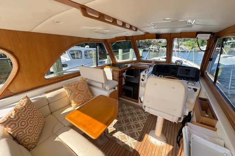 Slide: The Image of Luxurious 2002 Legacy Express yacht interior with plush seating, wooden accents, and scenic marina views. - 43