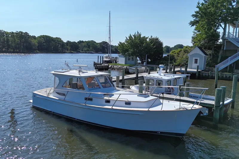 Slide: The Image of 2002 Legacy Express boat docked at a serene marina with lush greenery. - 5