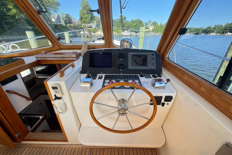 Slide: The Image of Helm of 2002 Legacy Express boat with wooden steering wheel and navigation equipment. - 39