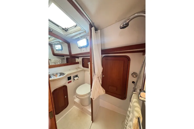 Slide: The Image of Compact bathroom in 2002 Legacy Express boat with wooden accents and porthole windows. - 47