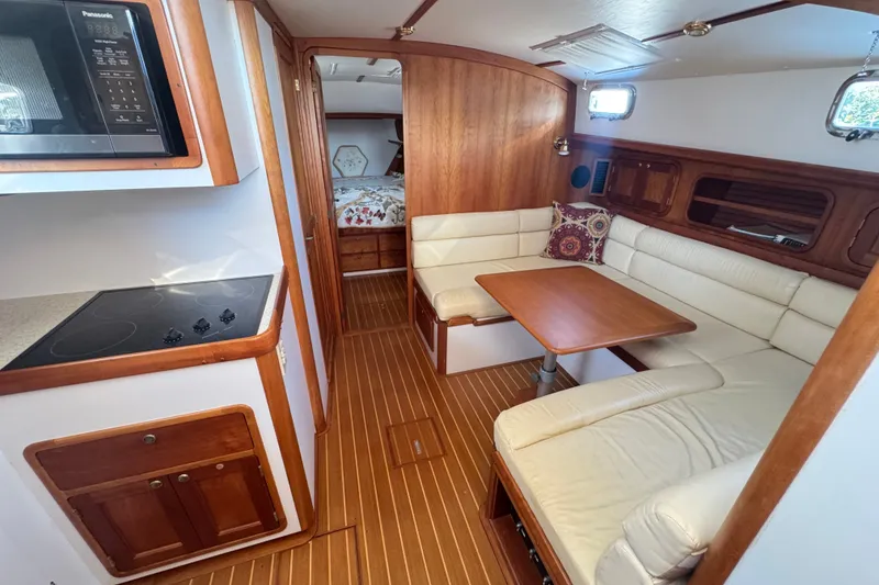 Slide: The Image of Interior of 2002 Legacy Express yacht with cozy seating, kitchenette, and wood accents. - 60