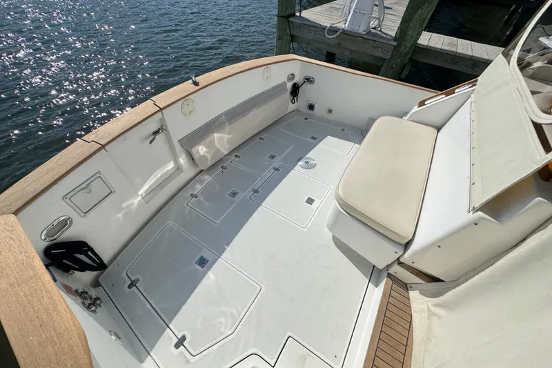 Slide: The Image of 2002 Legacy Express boat deck with seating, docked by sparkling water. - 67