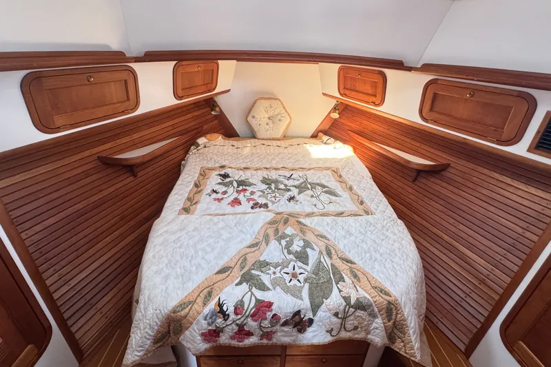 Slide: The Image of Cozy cabin bedroom in 2002 Legacy Express boat with floral quilt and wooden storage. - 42