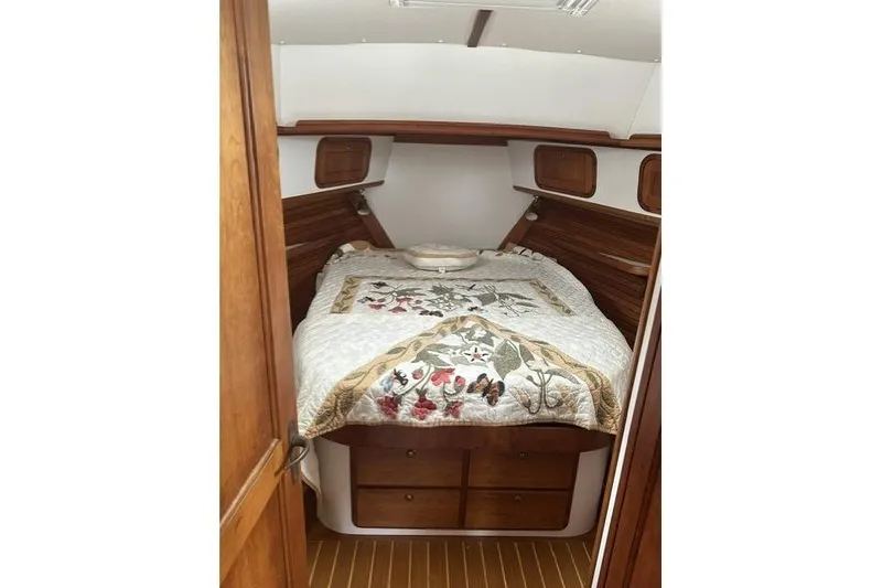 Slide: The Image of Cozy cabin interior of 2002 Legacy Express with wooden accents and floral quilt. - 15