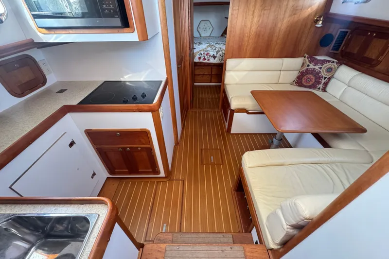 Slide: The Image of Interior of 2002 Legacy Express boat with kitchen and dining area. - 59