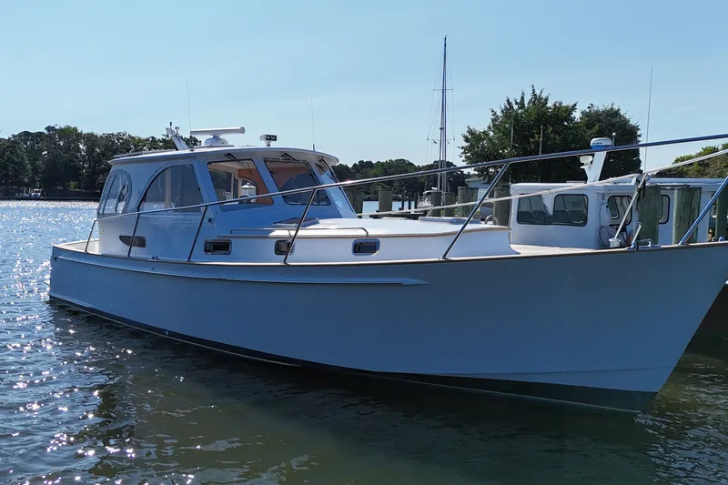 Slide: The Image of 2002 Legacy Express boat docked on a sunny day, surrounded by calm waters. - 36