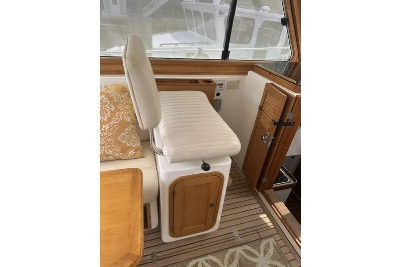Slide: The Image of Interior of a 2002 Legacy Express boat with cushioned seating and wooden accents. - 10