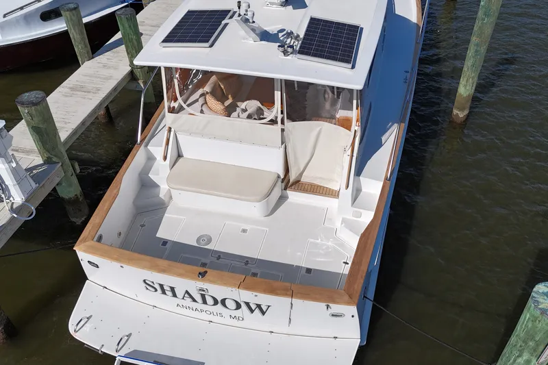 Slide: The Image of Aerial view of 2002 Legacy Express boat docked, featuring solar panels and seating area. - 38