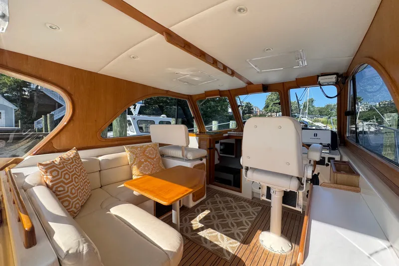 Slide: The Image of Interior of 2002 Legacy Express boat with seating, table, and helm station. - 40
