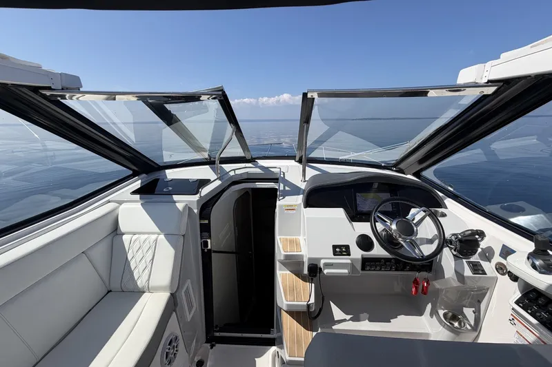 Slide: The Image of Cockpit view of 2021 Regal 35 Sport Coupe with open sunroof and ocean backdrop. - 15
