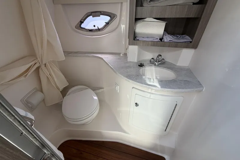Slide: The Image of Bathroom interior of 2021 Regal 35 Sport Coupe with sink, toilet, and storage shelves. - 33