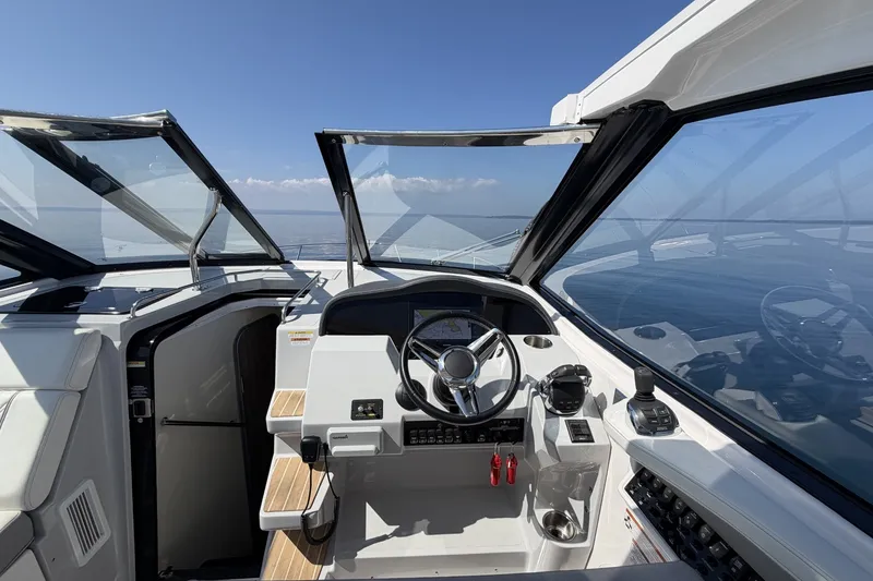 Slide: The Image of 2021 Regal 35 Sport Coupe helm with open sunroof, showcasing ocean view. - 16