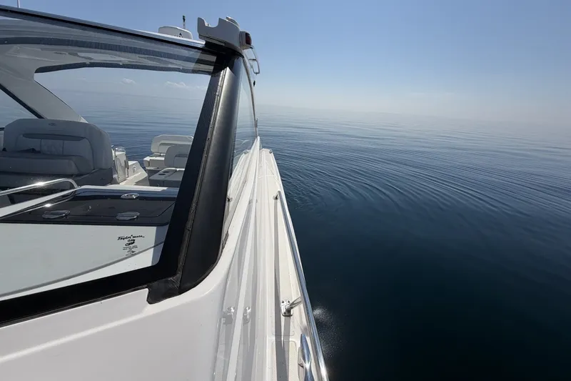 Slide: The Image of 2021 Regal 35 Sport Coupe cruising on calm, open water under clear skies. - 20