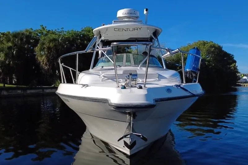 Slide: The Image of 2004 Century 3200 Walk-Around boat on calm water, front view, clear blue sky. - 10