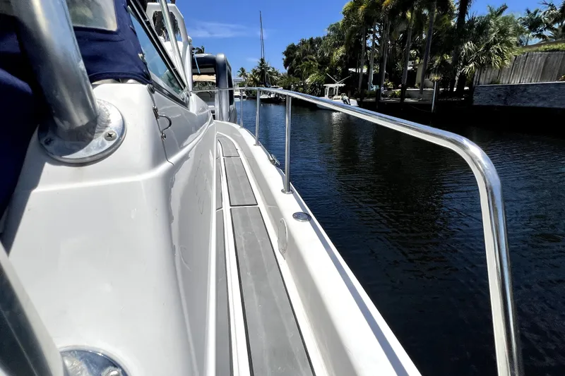 Slide: The Image of 2004 Century 3200 Walk-Around boat docked by a scenic canal with palm trees. - 70