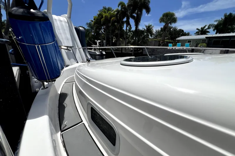 Slide: The Image of 2004 Century 3200 Walk-Around boat deck with blue fender, palm trees in background. - 36