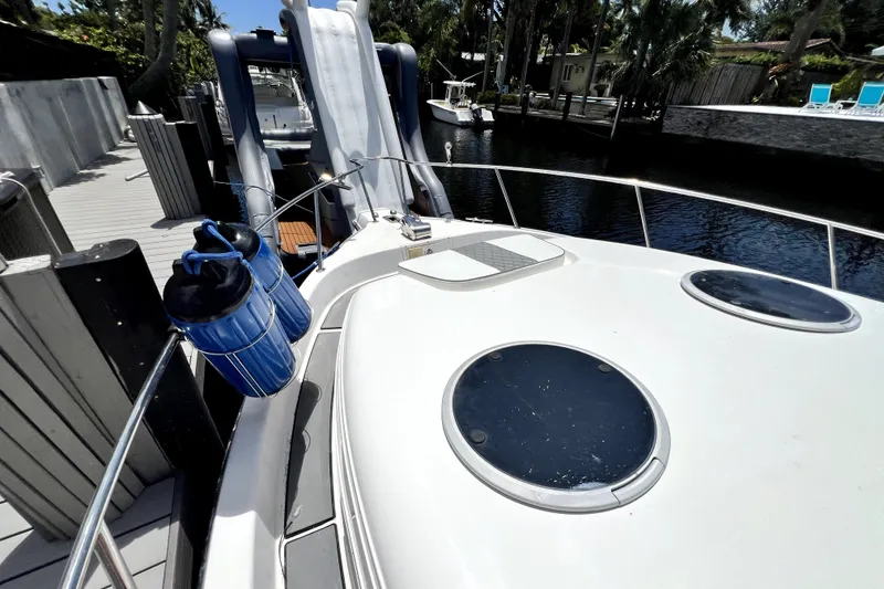 Slide: The Image of 2004 Century 3200 Walk-Around boat docked, featuring deck and water view. - 34