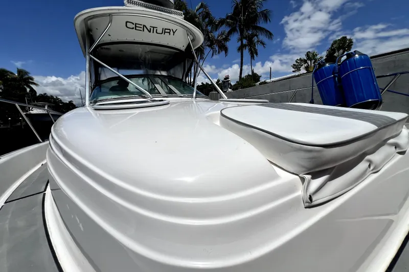 Slide: The Image of 2004 Century 3200 Walk-Around boat with sleek design, docked under a clear blue sky. - 43