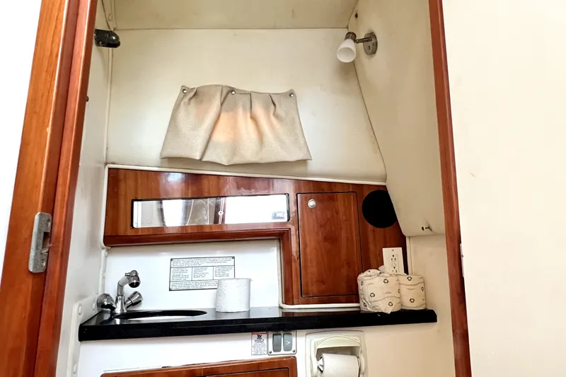 Slide: The Image of 2004 Century 3200 Walk-Around boat interior with sink, mirror, and storage cabinets. - 107