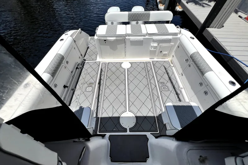 Slide: The Image of 2004 Century 3200 Walk-Around boat interior with cushioned seating and patterned flooring. - 89