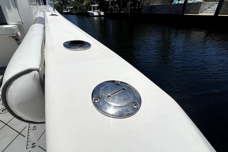 Slide: The Image of 2004 Century 3200 Walk-Around boat deck with chrome fittings by the water. - 72