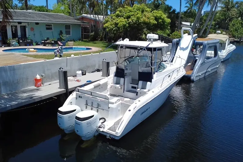 Slide: The Image of 2004 Century 3200 Walk-Around boat docked by a waterfront home with pool. - 6