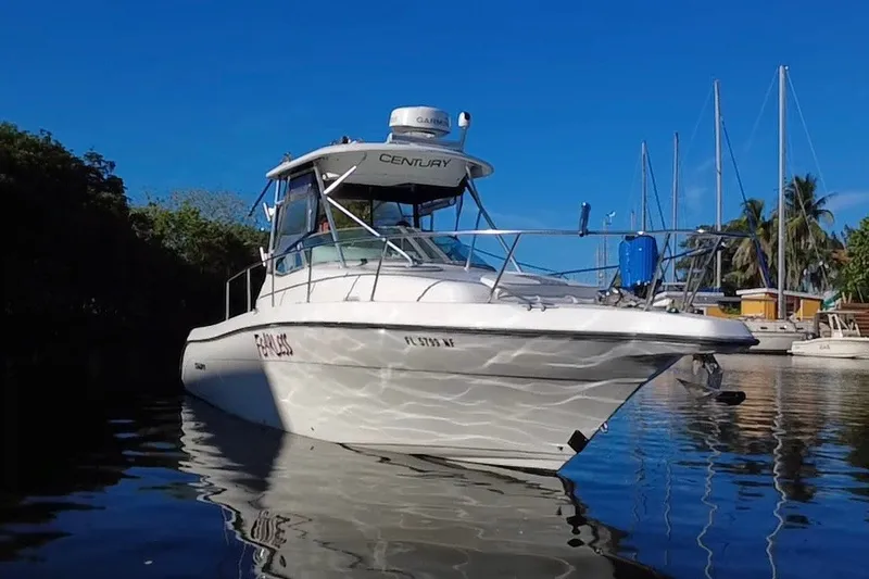 Slide: The Image of 2004 Century 3200 Walk-Around boat docked in a marina under clear blue skies. - 7
