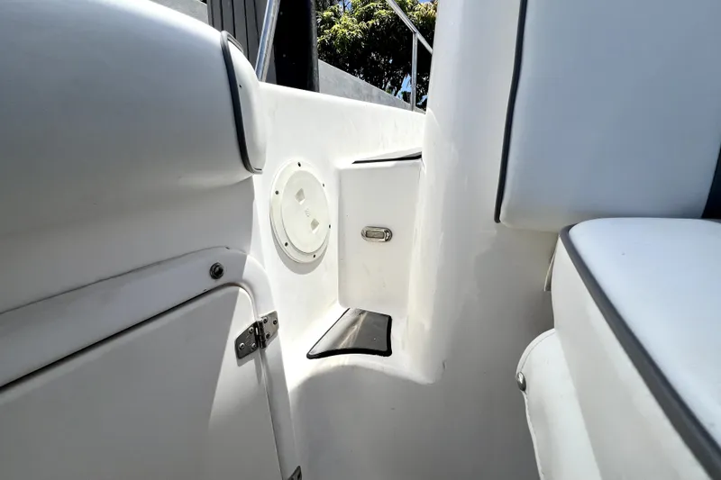 Slide: The Image of Interior view of a 2004 Century 3200 Walk-Around boat, featuring white seating and storage compartments. - 118