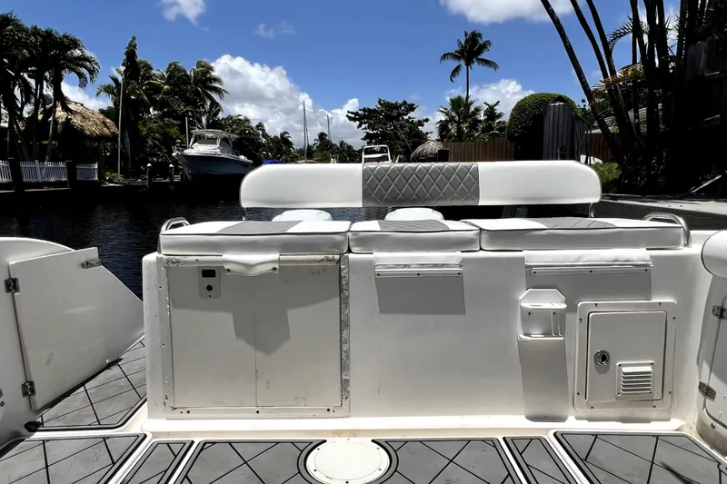 Slide: The Image of 2004 Century 3200 Walk-Around boat interior with seating, docked near palm trees. - 87