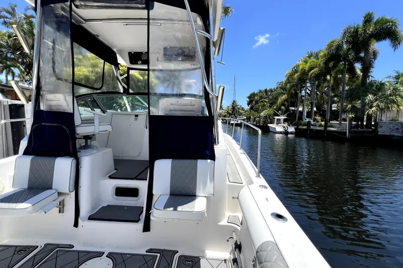 Slide: The Image of 2004 Century 3200 Walk-Around boat docked by a scenic canal with palm trees. - 84