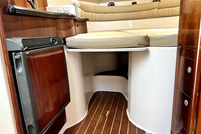 Slide: The Image of 2004 Century 3200 Walk-Around cabin interior with wood accents and compact fridge. - 68