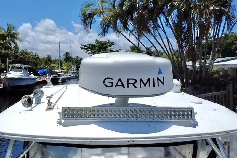 Slide: The Image of 2004 Century 3200 Walk-Around boat with Garmin radar, docked near palm trees. - 55