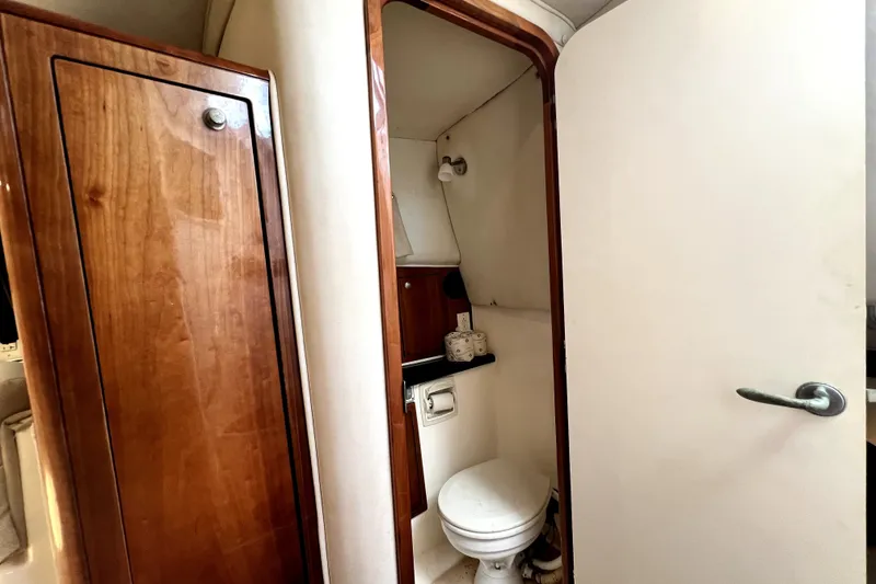 Slide: The Image of 2004 Century 3200 Walk-Around boat interior with wooden cabinetry and compact bathroom. - 109