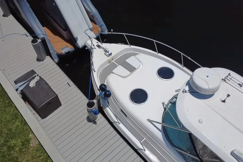 Slide: The Image of 2004 Century 3200 Walk-Around boat docked beside a wooden pier. - 17