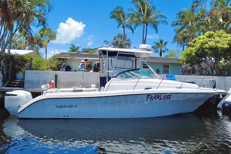 Slide: The Image of 2004 Century 3200 Walk-Around boat named "Fearless" docked near tropical palm trees. - 19
