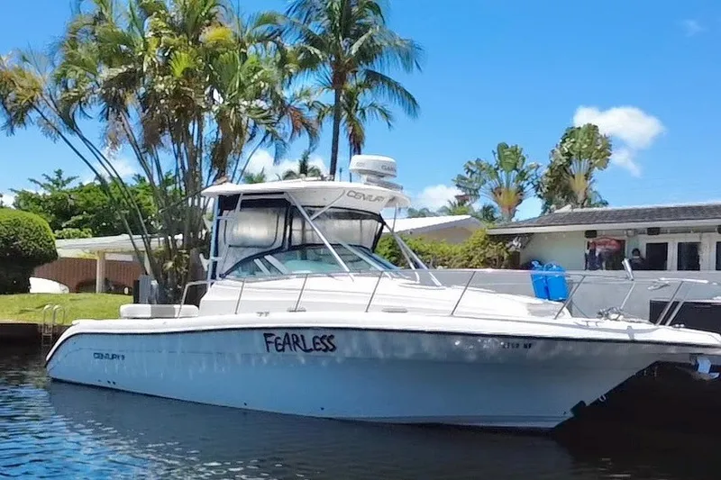 Slide: The Image of 2004 Century 3200 Walk-Around boat named "Fearless" docked near palm trees. - 18