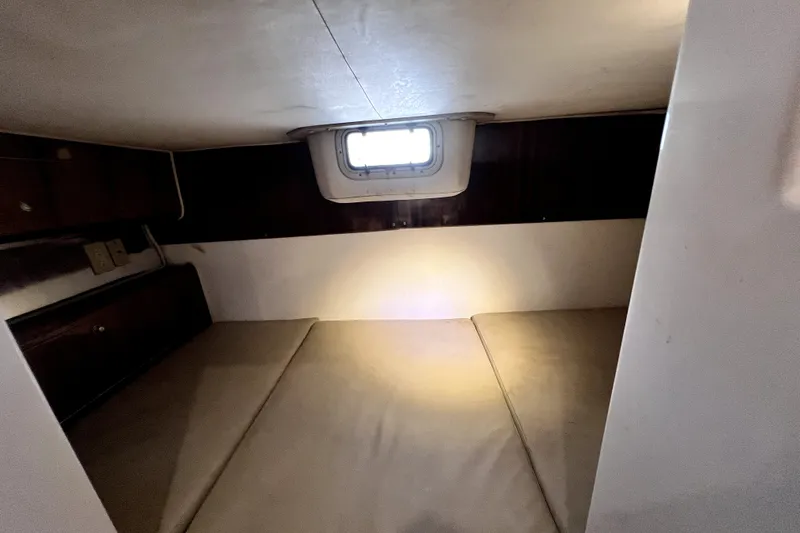 Slide: The Image of Interior cabin of 2004 Century 3200 Walk-Around boat, featuring a compact sleeping area. - 102