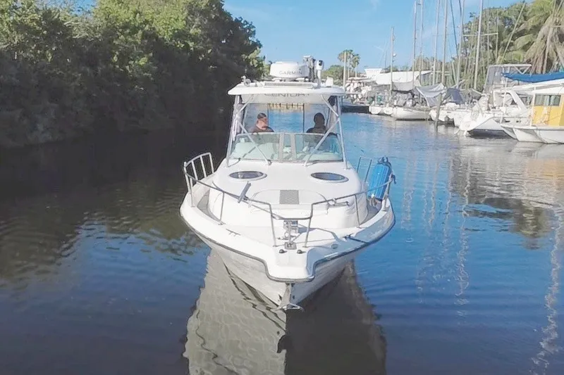 Slide: The Image of 2004 Century 3200 Walk-Around boat navigating a calm marina channel. - 9