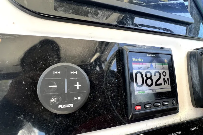 Slide: The Image of Control panel of a 2004 Century 3200 Walk-Around boat with Garmin and Fusion devices. - 94