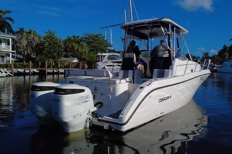 Slide: The Image of 2004 Century 3200 Walk-Around boat with Suzuki engines on a calm waterway. - 5