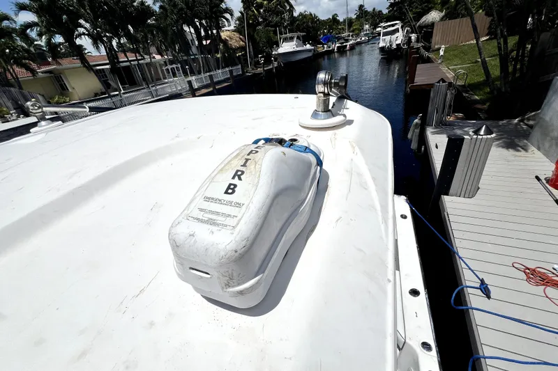 Slide: The Image of 2004 Century 3200 Walk-Around boat with EPIRB, docked in a scenic canal setting. - 119