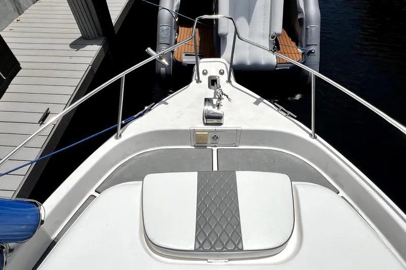 Slide: The Image of 2004 Century 3200 Walk-Around boat bow with seating and railing, docked beside a pier. - 50