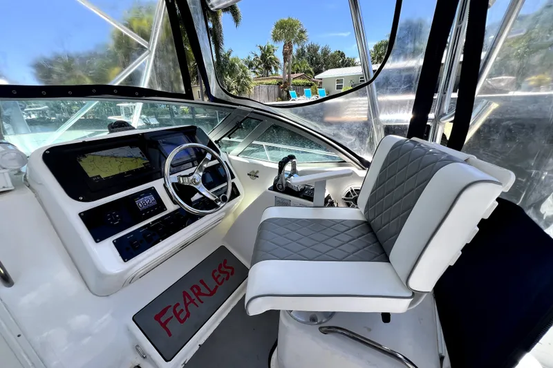 Slide: The Image of Century 3200 Walk-Around 2004 boat interior with steering wheel and cushioned seat. - 90