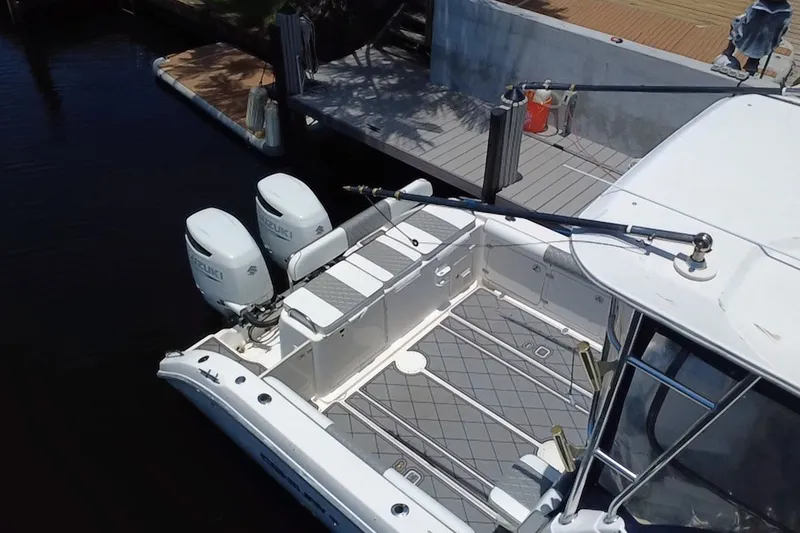 Slide: The Image of 2004 Century 3200 Walk-Around boat with dual Suzuki engines docked at a marina. - 13