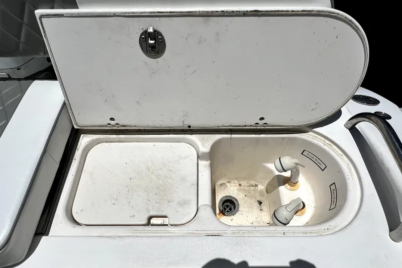 Slide: The Image of 2004 Century 3200 Walk-Around boat sink with open lid and faucet. - 86