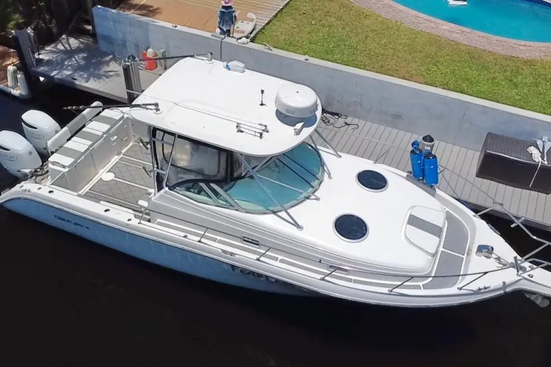 Slide: The Image of 2004 Century 3200 Walk-Around boat docked near a poolside, aerial view. - 22