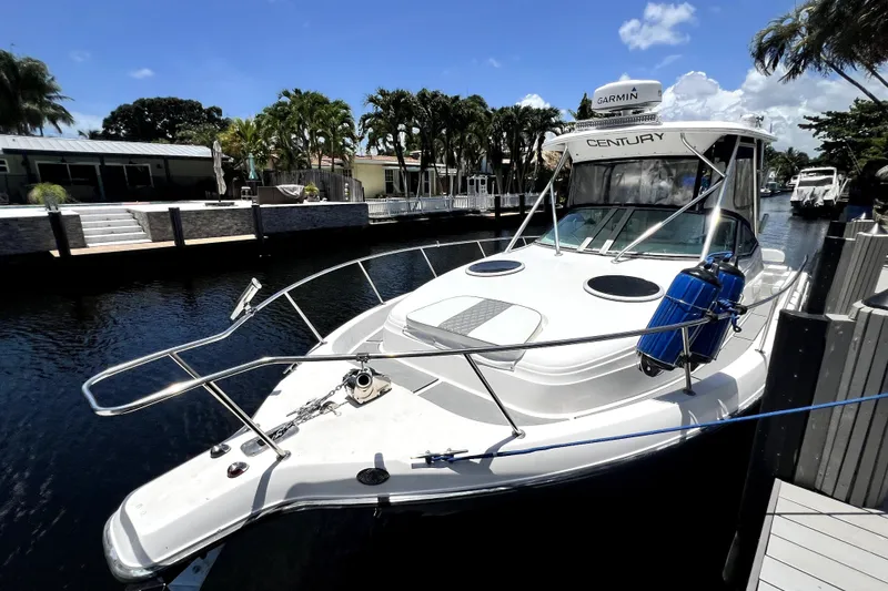 Slide: The Image of 2004 Century 3200 Walk-Around boat docked by a canal under a clear blue sky. - 29